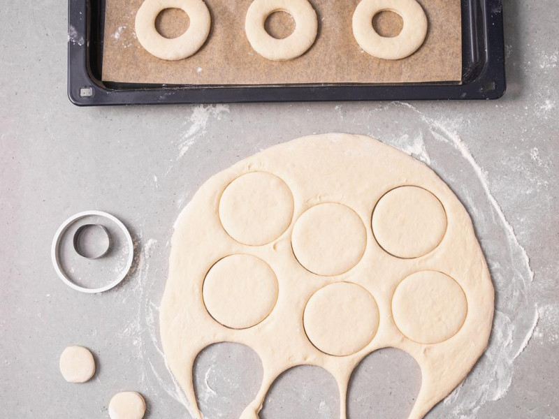 Wycinanie oponek z rozwałkowanego ciasta na blacie.