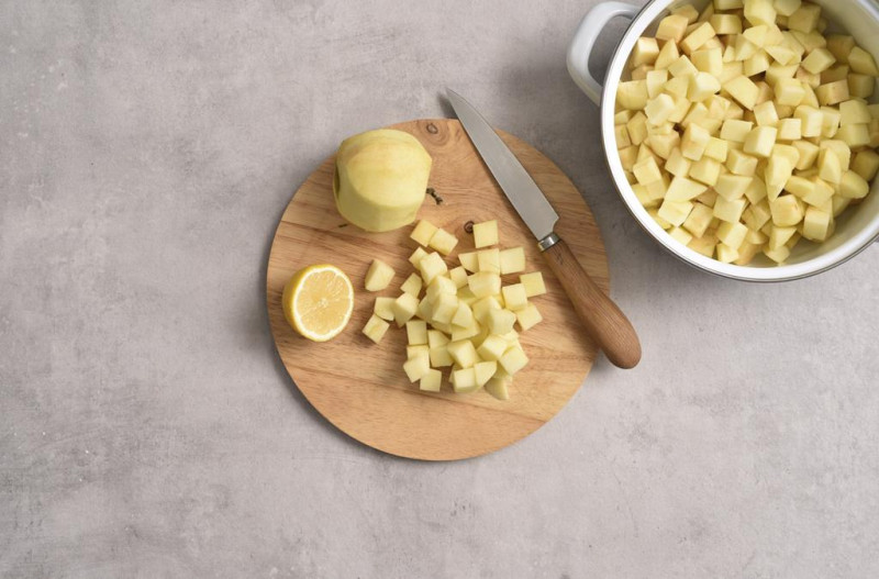 Pokrojone jabłka w kostkę w misie i na drewnianej desce.