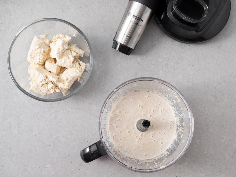 Zblendowane za pomocą blendera ręcznego firmy Bosch:orzechy nerkowca z napojem sojowym i syropem klonowym. Obok miska z pokruszonym tofu.