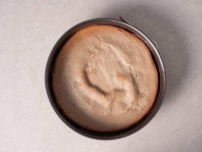 Tofurnik polany gorzką czekoladą. Obok orzechy włoskie.