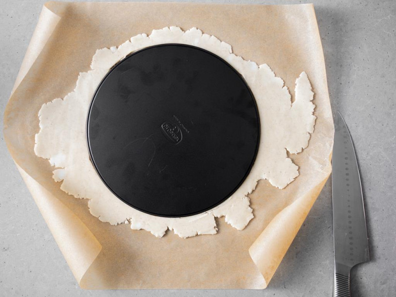 Rozwałkowane ciasto, a na nim spód od tortownicy.