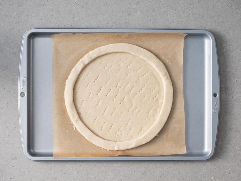 Wegańskie ciasto kruche ponaukłuwane widelcem na blasze Wilton.