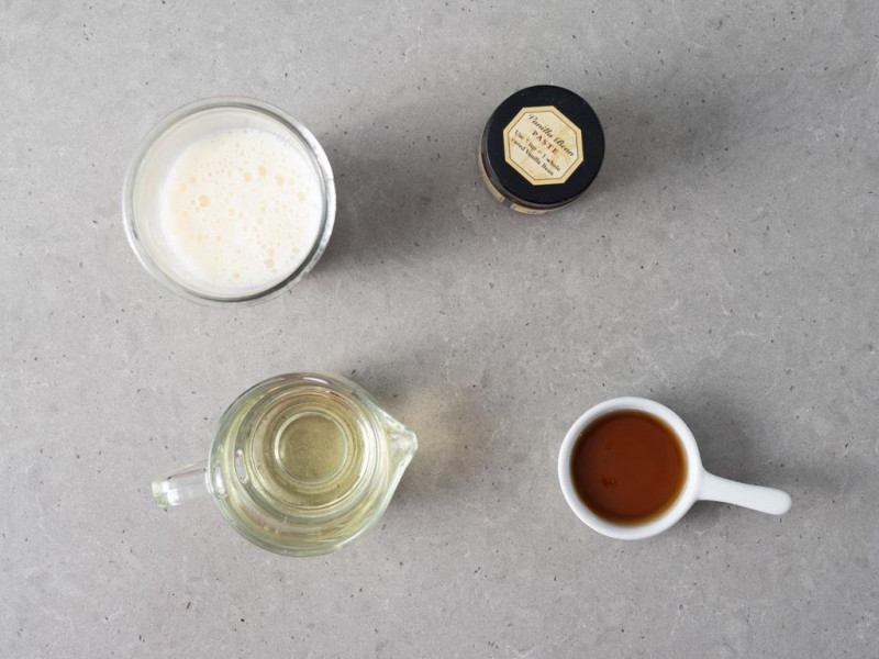 Napój sojowy w szklance, syrop klonowy w kokilce, olej rzepakowy w dzbanku i pasta z wanilii Taylor & Colledge