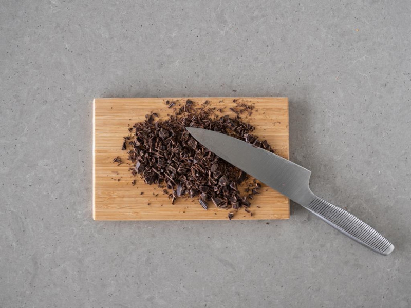 Pokrojona czekolada gorzka na drewnianej desce.