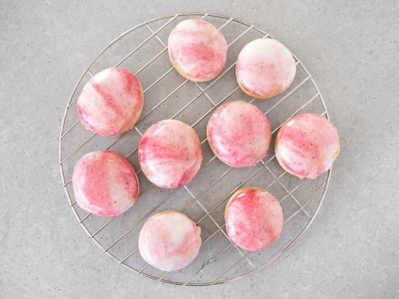 Pączki pieczone z biało-różowym lukrem z liofilizowanych owoców.