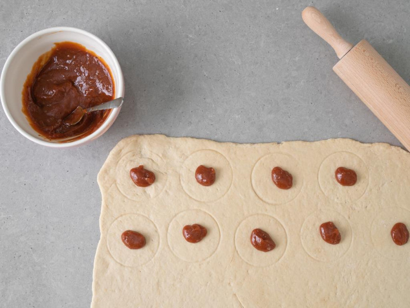 Rozłożone na cieście kleksy konfitury różanej.