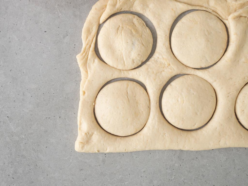 Powycinane pączki z wegańskiego ciasta drożdżowego.