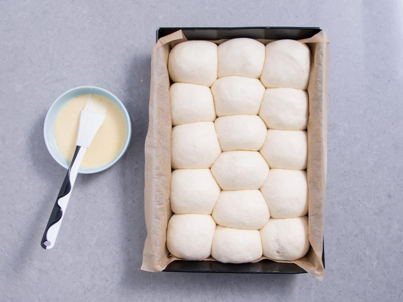 wyrośnięte bułeczki mleczne, jajko do posmarowania