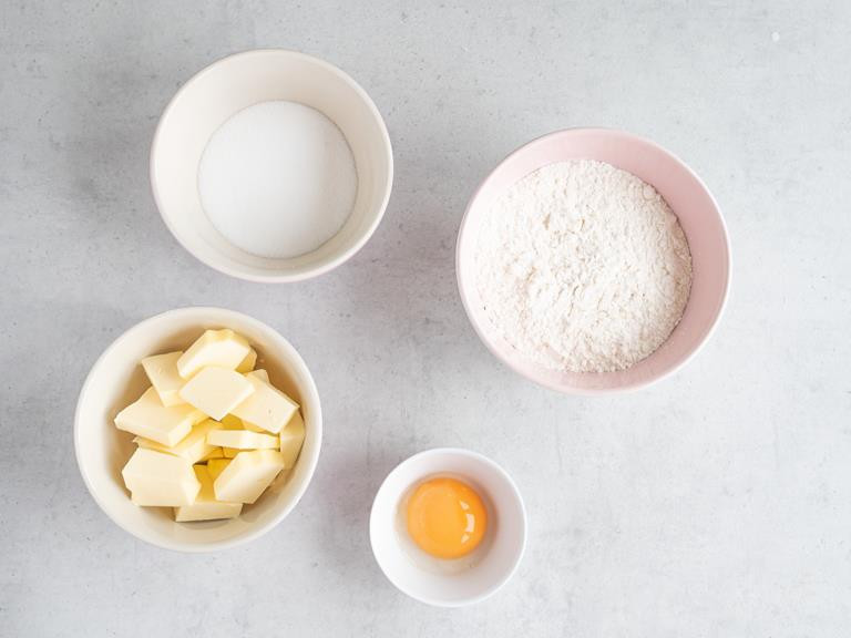 żółtka, masło, cukier, mąka w miseczkach