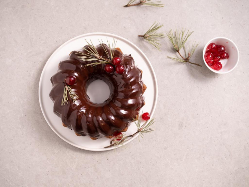 piernik bez glutenu udekorowany polewą z czekolady i kandyzowanymi wiśniami