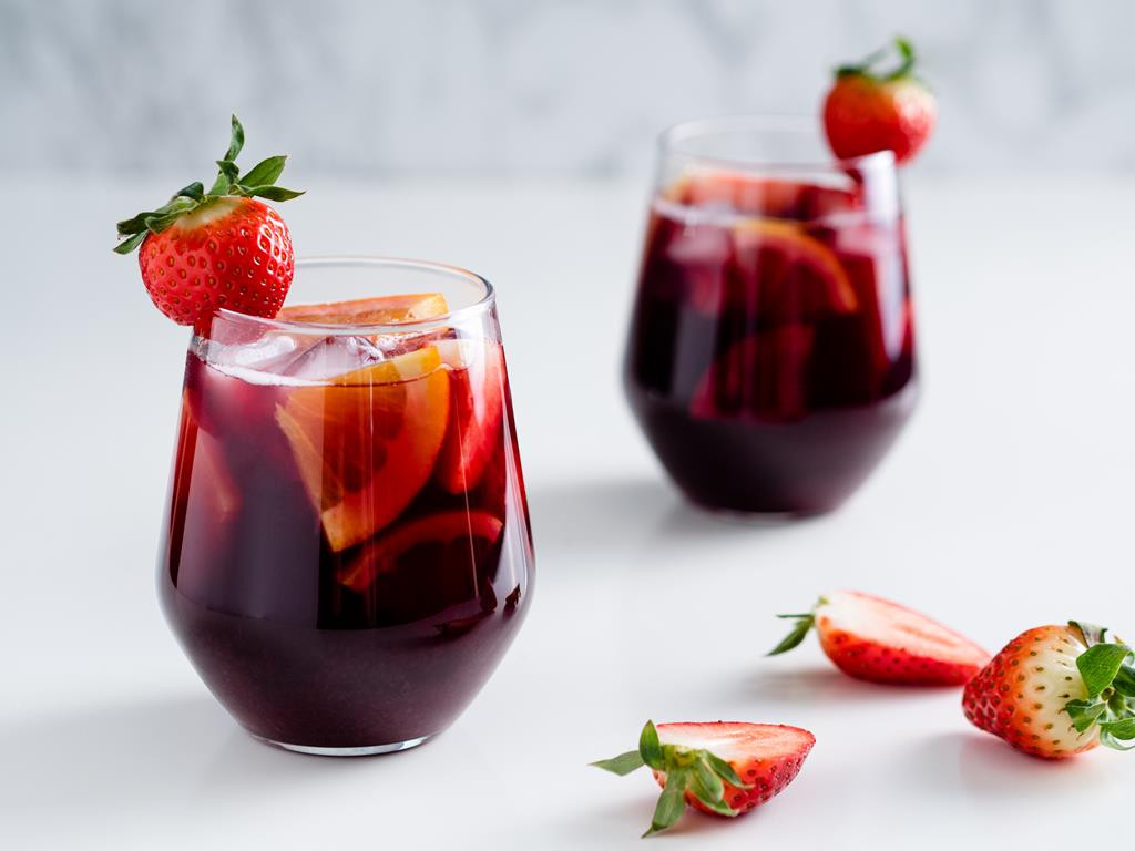 sangria , napój na bazie czerwonego wina z kawałkami owoców, kostkami lodu i truskawkami - wszystkiego słodkiego