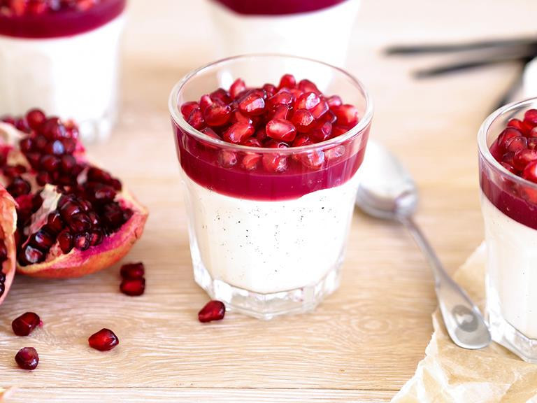 panna cotta udekorowana owocem granatu serwowana w miseczce