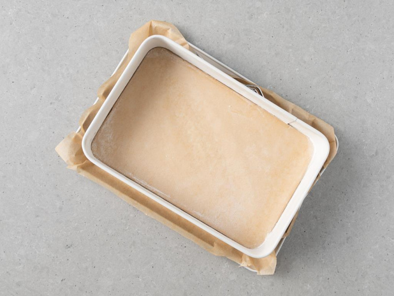 Prostokątna forma Dr. Oetkera wyłożona papierem do pieczenia.