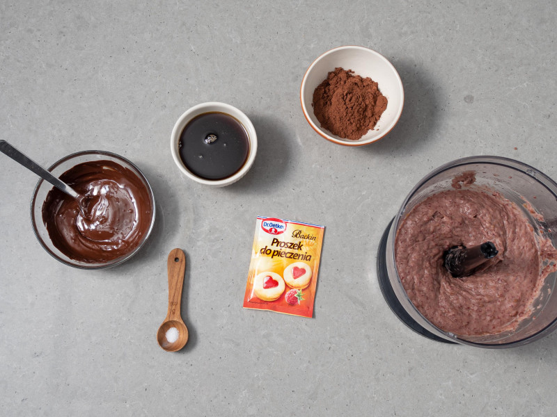 W misie malaksera zblendowana fasola. Obok w miseczkach rozpuszczona czekolada, syrop klonowy, kakao, proszek do pieczenia Dr. Oetkera i szczypta soli.