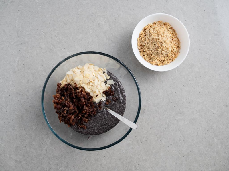 masa makowa w misce z dodanymi rodzynkami i płatkami migdałów, grubo posiekane orzechy włoskie w miseczce