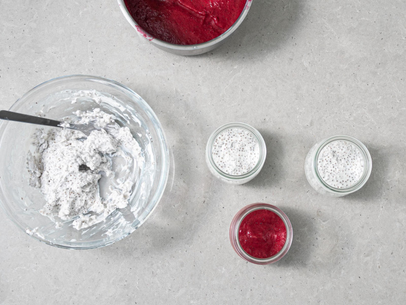 Napełnianie szklanych naczynek naprzemiennie sosem wiśniowym i mleczkiem kokosowym z nasionkami chia.