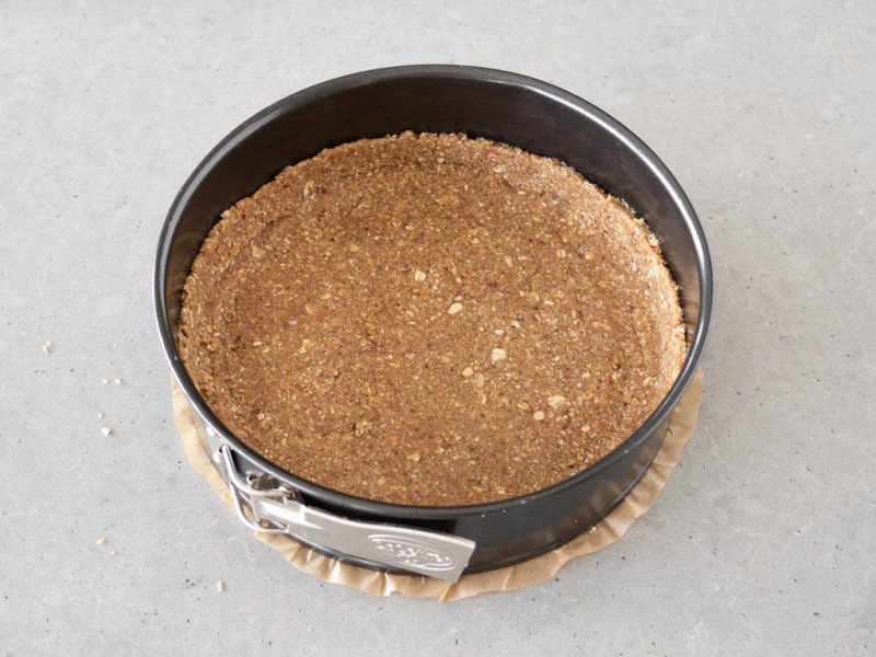 Masa z daktyli, migdałów, płatków owsianych i oleju kokosowego przełożona na spód formy