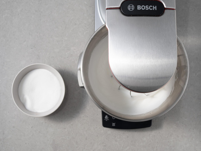 Podbite białka w robocie kuchennym firmy Bosch. Obok w miseczce cukier.
