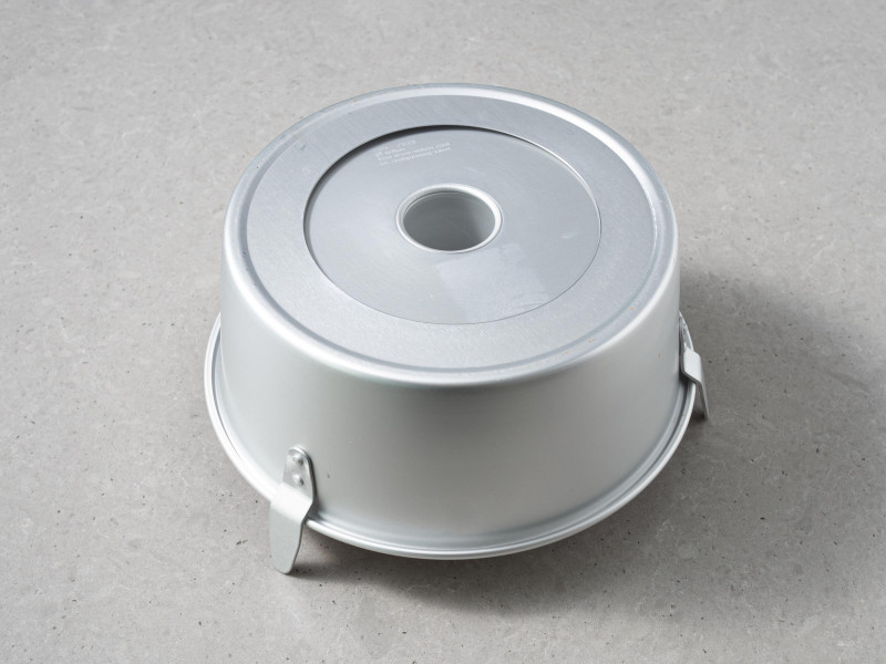 Studzące się ciasto anielskie w formie z kominem obróconej do góry dnem i opartej na "nóżkach"..