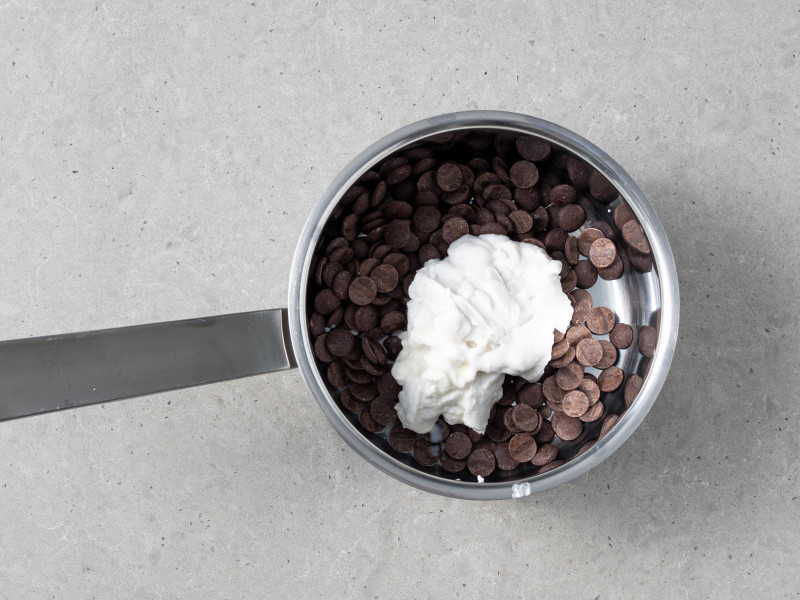 Czekolada gorzka i mleczko kokosowe w garnku.