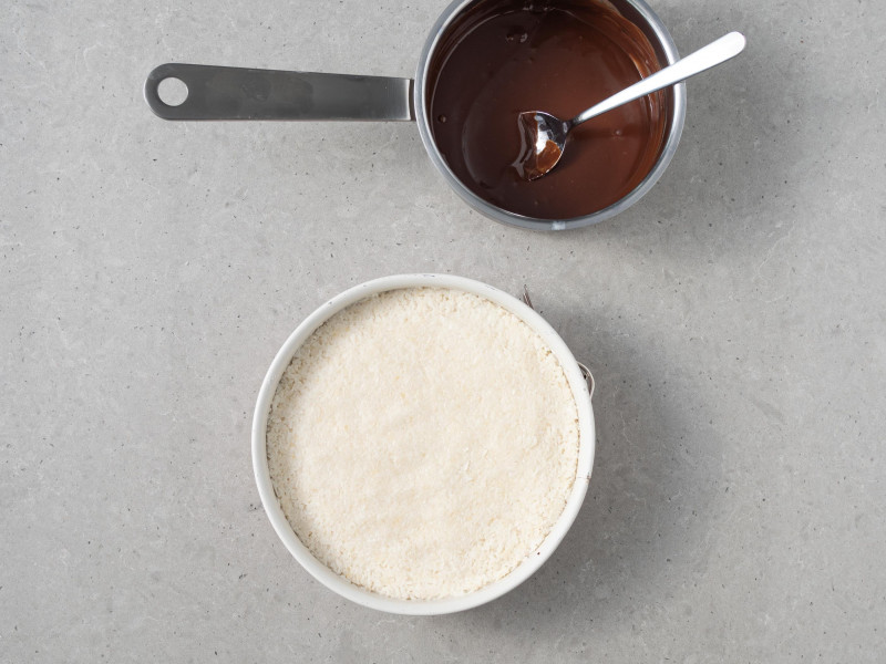 W garnku polewa czekoladowa z mleczkiem kokosowym. Obok masa kokosowa.