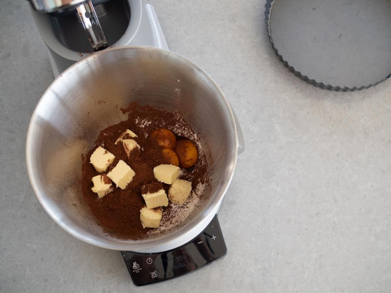 mąka, cukier puder, sól, kakao, żółtka i masło w misie robota kuchennego