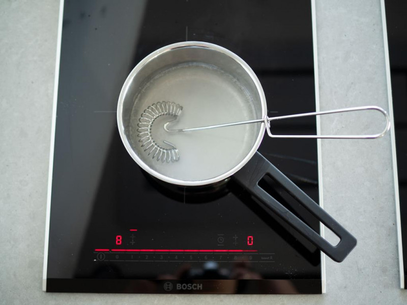 rondelek z wodą zagotowaną z cukrem na palniku kuchenki