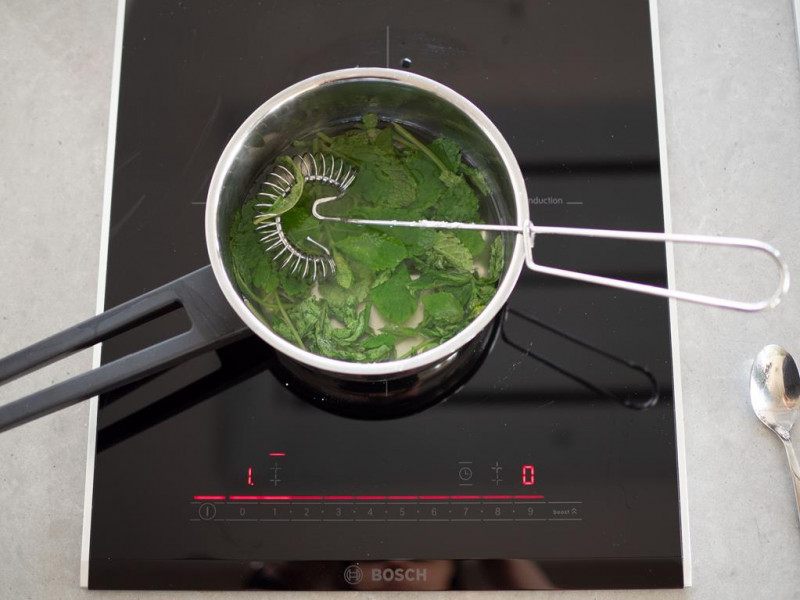 świeże listki mięty dodane do rondelka z wodą zagotowaną z cukrem