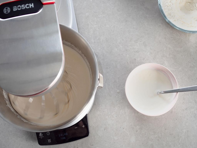 na stole robot kuchenny bosch z przygotowywanym ciastem obok w miseczce jogurt naturalny