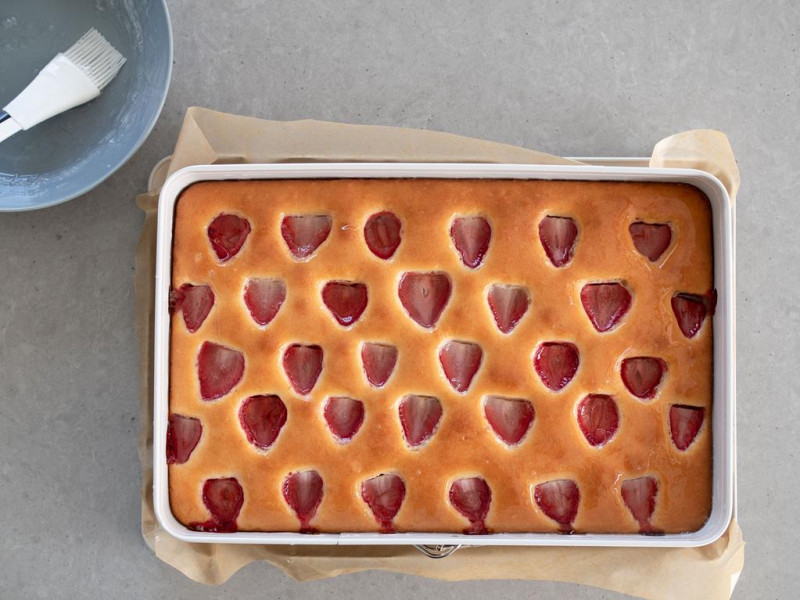 ciasto jogurtowe z truskawkami obok miseczka z galaretką krystaliczną