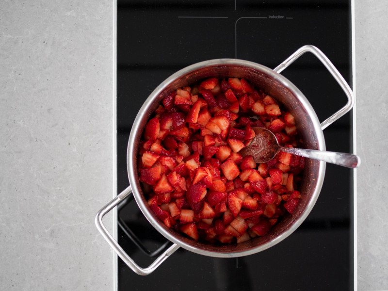 Truskawki wymieszane z żelfixem w garnku.