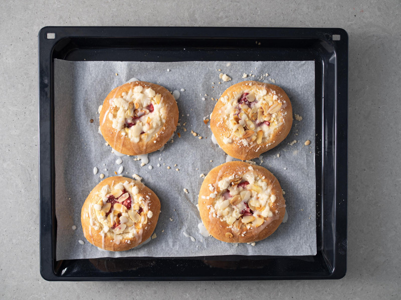 Upieczone drożdżówki wegańskie, polane lukrem cytrynowym.