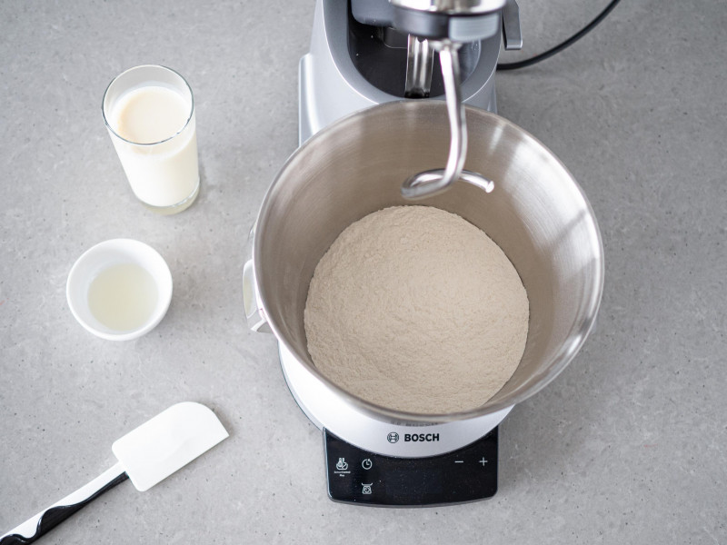 W misie wymieszane suche składniki. Obok ciepłe mleko i rozpuszczony olej kokosowy.