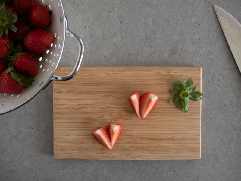 na desce kawałki świeżych truskawek