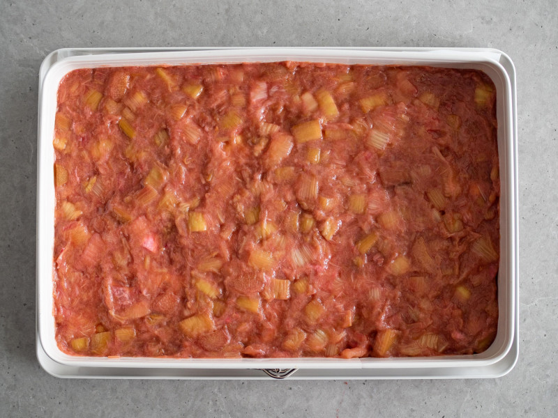 w dużej formie do pieczenia wyłożone nadzienie rabarbarowe do ciasta z rabarbarem i bezą