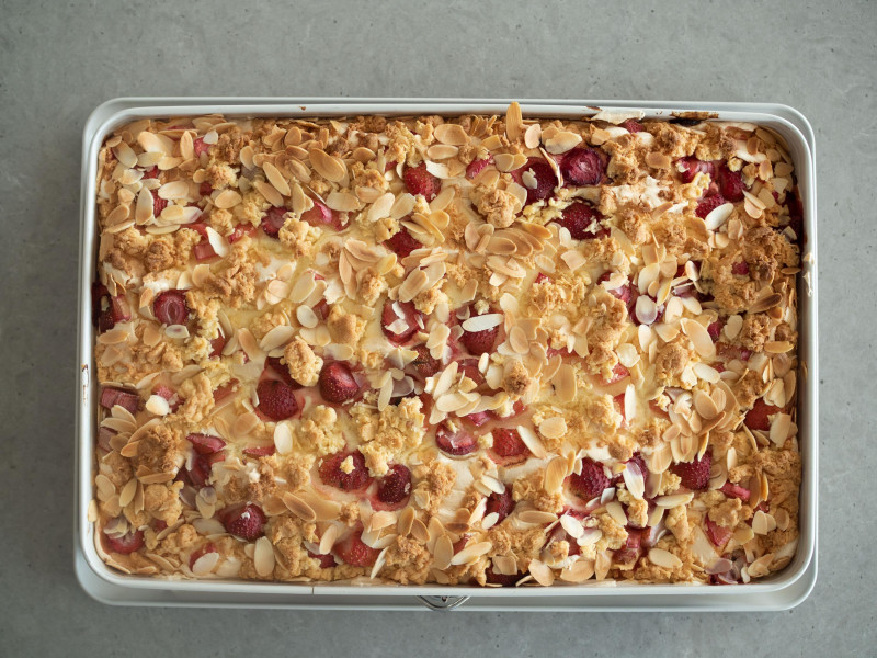 upieczone kruche ciasto z pianką, truskawkami, rabarbarem i płatkami migdałów