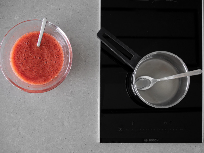 W garnku woda z agarem, a obok zblendowane truskawki z cukrem i sokiem z cytryny.