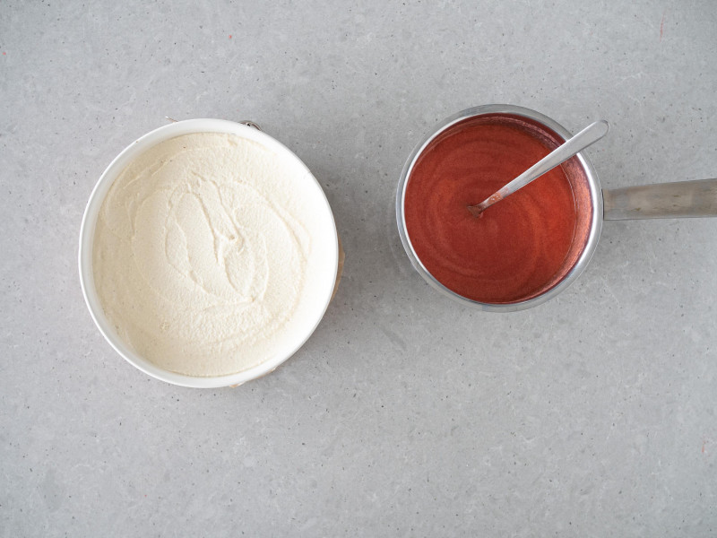 Masa z nerkowców i tofu w tortownicy. Obok galaretka truskawkowa z agarem w garnku.