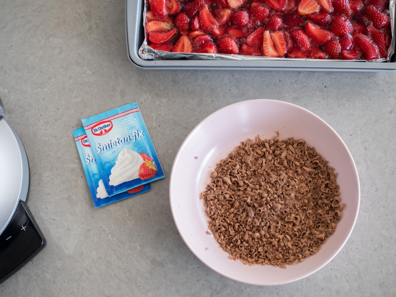 w różowej miseczce starta na wiórki czekolada, obok śmietan fix dr. oetkera