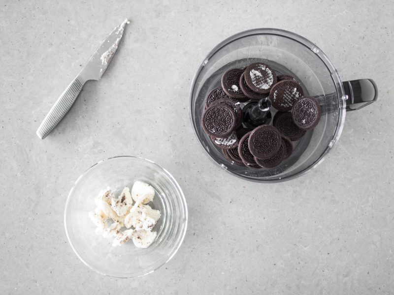 W pojemniku malaksera ciasteczka oreo, obok  w miseczce nadzienie z ciasteczek.