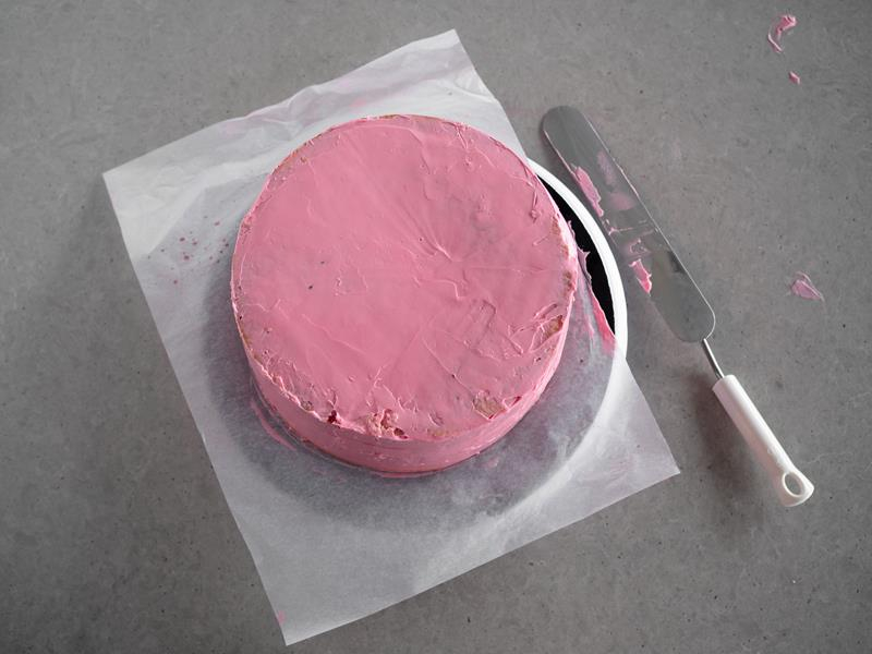 różowy tort malinowy obłożony kremem maślanym