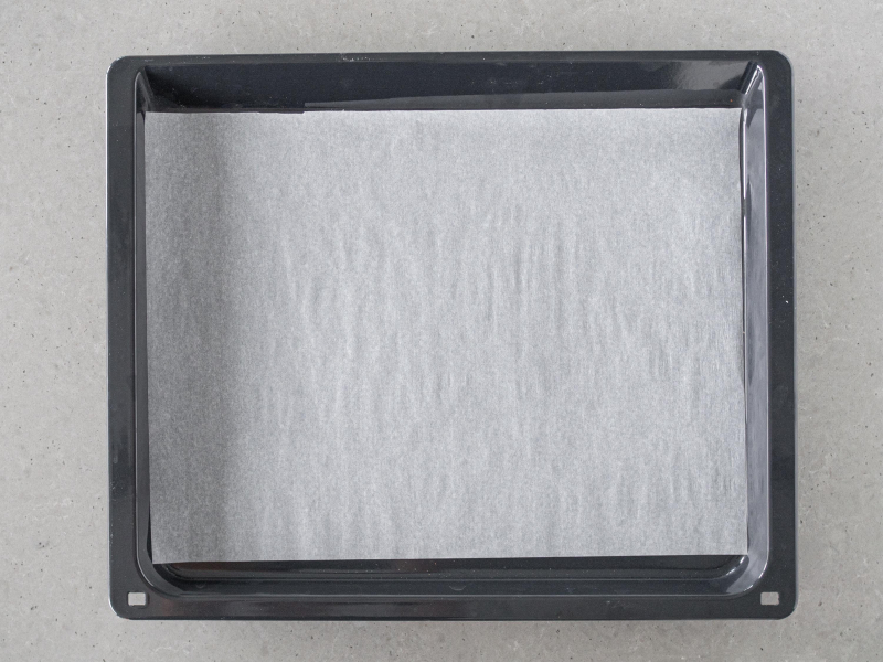 Blacha z wyposażenia piekarnika wyłożona papierem do pieczenia.