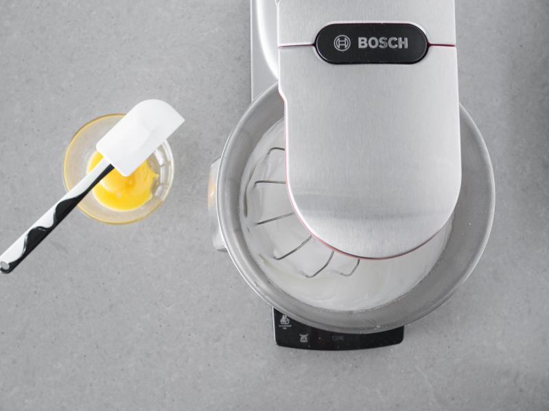 W misce żółtka. Obok ubita beza z białek i cukru.