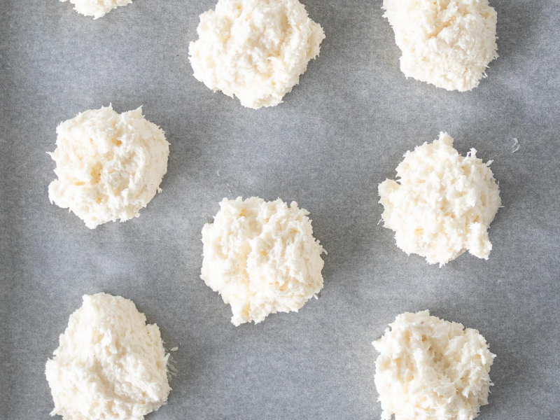 Nałożone kokosanki na blachę wyłożoną papierem do pieczenia.