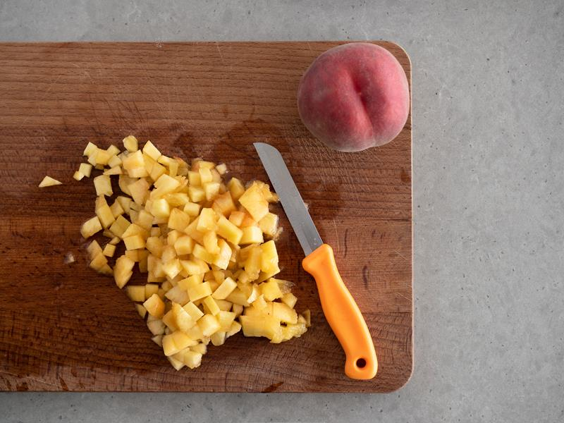 na drewnianej desce pokrojona brzoskwinia