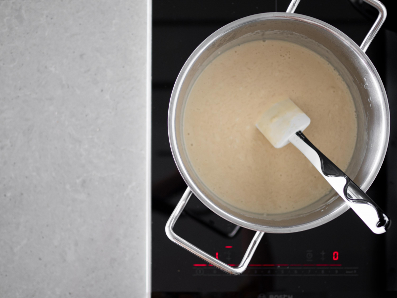 Gotujący się ryż na napoju sojowym w garnku.