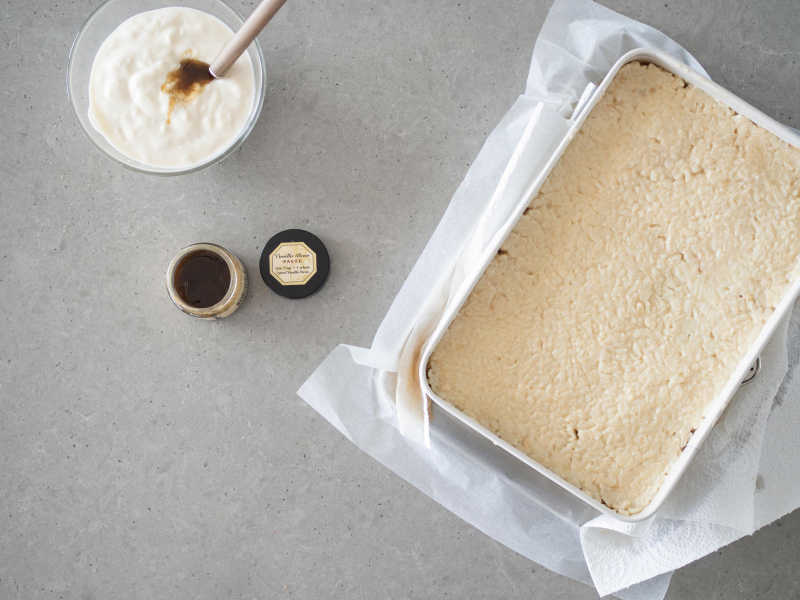 W formie rozłożony ryż z jabłkami. Obok jogurt sojowy z pastą z wanilii.