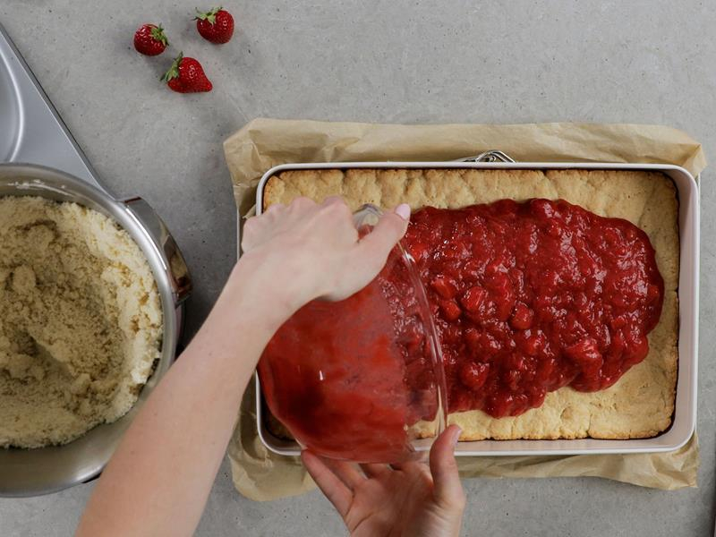 w formie spód ciasta z warstwą podgotowanych owoców sezonowych