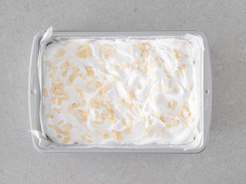 Upieczona beza z aquafaby posypana p艂atkami migda艂贸w w formie prostok膮tnej Wilton.