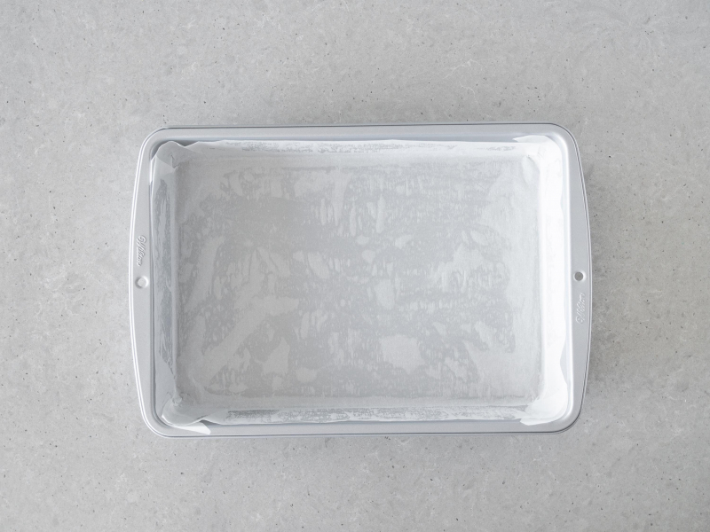 Prostok膮tna forma Wilton wy艂o偶ona papierem do pieczenia.